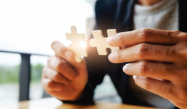 Business woman hands connecting jigsaw puzzle. Business solutions, success and strategy concept. Businessman hand connecting jigsaw puzzle.Close up photo with selective focus.